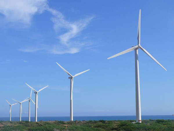 Seis turbinas eólicas en una playa, ejemplo del consumo sostenible